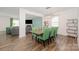 Dining area showcasing a wooden table with seating for six, complemented by modern lighting and wood flooring at 711 Saddlebred Ln, Locust, NC 28097