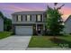 Charming two-story home featuring stone accents, a two-car garage, and a manicured front lawn at 711 Saddlebred Ln, Locust, NC 28097