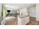 Open-concept kitchen with white cabinets, granite counters, and a seamless transition to the dining and living areas at 711 Saddlebred Ln, Locust, NC 28097