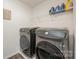Modern laundry room featuring front-load washer and dryer with shelving above at 711 Saddlebred Ln, Locust, NC 28097