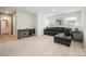 Bright living room with a gray sectional sofa, entertainment center, and neutral carpet at 711 Saddlebred Ln, Locust, NC 28097