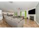 Spacious living room with wood floors, a cozy fireplace, a ceiling fan, and an adjacent open-concept kitchen and dining area at 711 Saddlebred Ln, Locust, NC 28097