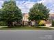 Charming two-story Tudor home with brick facade, gable roof, manicured lawn, and mature trees at 7620 Caspian Dr, Waxhaw, NC 28173