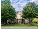 Charming two-story Tudor home with brick facade, gable roof, manicured lawn, and mature trees at 7620 Caspian Dr, Waxhaw, NC 28173