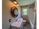 Bathroom features a vanity with a round mirror, natural light and a tub at 8095 New St, Mount Pleasant, NC 28124