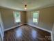 Bedroom features two windows, hardwood floors, tan walls and white trim at 8095 New St, Mount Pleasant, NC 28124
