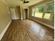 Bedroom featuring wood-look flooring, a ceiling fan and a large window with backyard views at 8095 New St, Mount Pleasant, NC 28124