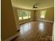 Bedroom with wood-look floors, ceiling fan, and windows offering natural light at 8095 New St, Mount Pleasant, NC 28124