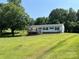 Exterior shot of the back of the house with a deck and grassy yard at 8095 New St, Mount Pleasant, NC 28124