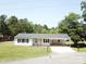 Inviting single-story home with carport, black shutters, and a lush green lawn at 8095 New St, Mount Pleasant, NC 28124