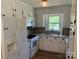 Well-lit kitchen with white appliances and cabinets, with stone-look countertops and backsplash at 8095 New St, Mount Pleasant, NC 28124
