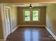 Sun-drenched living room with a ceiling fan, closet, and views of the surrounding greenery at 8095 New St, Mount Pleasant, NC 28124