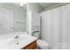 This bathroom features a vanity with storage, a toilet, and a shower with white shower curtain at 8808 Palmutum Pl, Charlotte, NC 28269