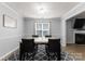 Dining area with modern table and chairs, offering a view of the living room at 8808 Palmutum Pl, Charlotte, NC 28269