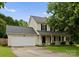 Charming two-story home with a well-maintained lawn and a two-car garage on a sunny day at 8808 Palmutum Pl, Charlotte, NC 28269