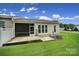 Backyard featuring a screened porch, concrete patio, green grass, and an air conditioning unit at 9020 Smokey Hill Ln, Fort Mill, SC 29707