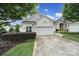 Charming single-story home featuring a manicured lawn and a driveway with a two-car garage at 9020 Smokey Hill Ln, Fort Mill, SC 29707