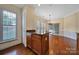 Bright eat-in kitchen features rich wood floors, cabinets, and granite countertop island, plus large window with plantation shutters at 9020 Smokey Hill Ln, Fort Mill, SC 29707