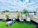 Inviting rooftop terrace with artificial grass, city views, egg chairs, and lounge furniture at 925 Westbrook Dr # B, Charlotte, NC 28202