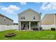 Spacious backyard featuring a covered patio, grill, fire pit and privacy fence at 9733 Paper Tree Rd, Charlotte, NC 28227