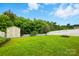 Picturesque backyard with storage shed, fire pit, lush green grass and white fence at 9733 Paper Tree Rd, Charlotte, NC 28227