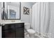 Neutral bathroom featuring vanity with dark cabinets and shower with striped curtain at 9733 Paper Tree Rd, Charlotte, NC 28227