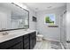 Bathroom with a double sink vanity, shower, and natural light from the window at 9733 Paper Tree Rd, Charlotte, NC 28227