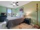 Cozy bedroom with green walls, window, ceiling fan, and neutral colored bedding at 9733 Paper Tree Rd, Charlotte, NC 28227