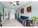 Inviting bedroom with light blue walls, small blue couch, and wood-look floors at 9733 Paper Tree Rd, Charlotte, NC 28227