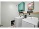 Bright laundry room with modern appliances, overhead cabinets and a wooden shelf at 9733 Paper Tree Rd, Charlotte, NC 28227