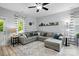 Open-concept living room featuring a comfortable gray sectional sofa, stylish rug, and plenty of natural light at 9733 Paper Tree Rd, Charlotte, NC 28227