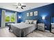 Blue main bedroom with a large window, ceiling fan, and neutral bedding at 9733 Paper Tree Rd, Charlotte, NC 28227