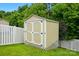New backyard storage shed on lush green lawn behind a white fence at 9733 Paper Tree Rd, Charlotte, NC 28227
