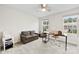 Bright bedroom features a workspace with desk and chair, a sofa, and natural light from two windows at 1022 Hinson Forest Rd, Monroe, NC 28110