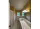 Retro bathroom featuring vintage yellow wallpaper and white tile, giving it a distinct charm at 1115 Dumbarton Rd, Gastonia, NC 28054