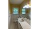 Well-lit bathroom with retro yellow wallpaper and white tiled surfaces at 1115 Dumbarton Rd, Gastonia, NC 28054