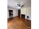 Cozy living room featuring hardwood floors, a ceiling fan, and a classic brick fireplace at 1115 Dumbarton Rd, Gastonia, NC 28054