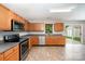 Well-lit kitchen features wooden cabinets, stainless steel appliances, and tile flooring near a sliding glass door at 116 Amber Woods Dr, Tega Cay, SC 29708