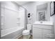 Clean bathroom features white fixtures, a tub-shower combo, and a sleek mirror for a modern, minimalist look at 12013 Beaux Art Ln, Charlotte, NC 28214