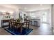 Open-concept dining area with wood table, stylish seating, and a view into the modern kitchen at 12013 Beaux Art Ln, Charlotte, NC 28214