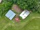 Close aerial of two rural outbuildings and a silo on lush green farmland at 13101 Pine Bluff Rd, Midland, NC 28107