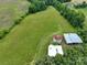 Aerial view of lush farmland with outbuildings including a barn and a silo, surrounded by mature trees at 13101 Pine Bluff Rd, Midland, NC 28107
