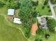 Aerial view of a house, farmland, mature trees and an outbuilding with a silo at 13101 Pine Bluff Rd, Midland, NC 28107
