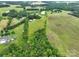 An expansive, lush, green aerial view of farmland and a house, with many mature trees at 13101 Pine Bluff Rd, Midland, NC 28107
