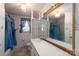 A full bathroom with white tile, blue curtains, and a large mirror at 13101 Pine Bluff Rd, Midland, NC 28107