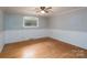 The bedroom has wood floors, light colored walls, and a ceiling fan with overhead lighting at 13101 Pine Bluff Rd, Midland, NC 28107