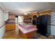 Well-lit kitchen with wood cabinets, black appliances, and an island with a sink at 13101 Pine Bluff Rd, Midland, NC 28107