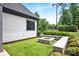 Enjoy this home's spacious backyard with a fire pit feature surrounded by lush greenery at 14105 Ryker Way, Davidson, NC 28036