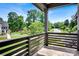 An exterior balcony view of the street, lawn and home with gray posts and horizontal railings under a blue sky at 14105 Ryker Way, Davidson, NC 28036