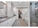 Bright bathroom with double vanity, soaking tub, glass shower, and access to the walk-in closet at 14105 Ryker Way, Davidson, NC 28036